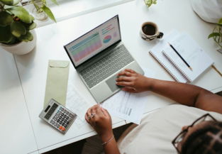 a person sitting at a table with a laptop